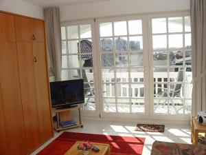 a living room with a television and a large window at Ferienwohnung mit Balkon und Tiefgarage in Ostseebad Sellin