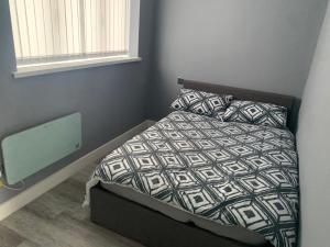 a bedroom with a bed and a window at Ty Haf in Aberdare