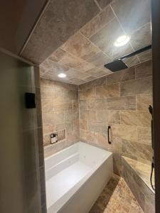 a bath tub in a bathroom with tile walls at Cottage style home close to golfing and lake 