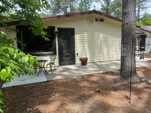 un garage avec une table et des chaises devant une maison dans l'établissement Cottage style home close to golfing and lake, à Whispering Pines