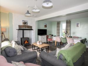 a living room with couches and a fire place at Tregynrig Bach in Cemaes Bay