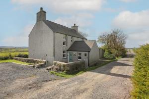 an old stone house on a dirt road at Tregynrig Bach in Cemaes Bay