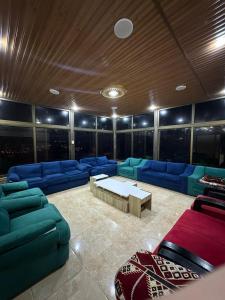 a living room with blue couches and a table at فيلا الجبل in Sūf