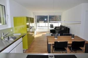 een keuken en een woonkamer met een tafel en stoelen bij La Perla A2 in Scuol