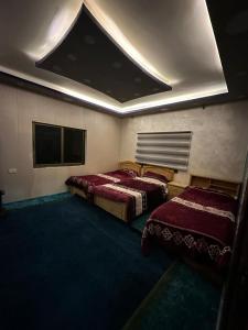 a room with two beds and a flat screen tv at فيلا الجبل in Sūf