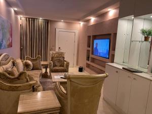 a living room with a couch and a table and a tv at The Palms Hotel in Abuja