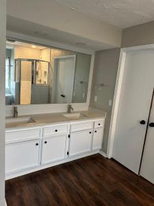 Un baño con dos lavabos y un espejo grande. en Hefner Loft, en Oklahoma City