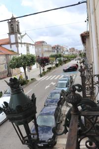 uma varanda com carros estacionados numa rua da cidade em Pension La Corredera em Tui