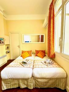 2 Betten in einem Schlafzimmer mit Fenster in der Unterkunft Studio au calme à deux pas du Palais des Festivals in Cannes