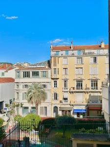 un gran edificio con una palmera delante en Studio au calme à deux pas du Palais des Festivals, en Cannes