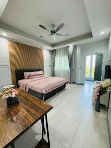 a bedroom with a bed and a table in it at Michelle house pool villa in Pattaya South