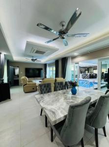 a living room with a large marble table and chairs at Michelle house pool villa in Pattaya South