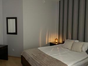 a bedroom with a bed with a mirror and a lamp at CentralVibeWro in Wrocław