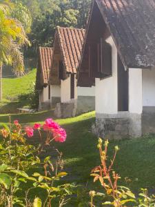 un groupe de maisons avec des fleurs roses dans la cour dans l'établissement Pousada Portal de Lumiar, à Lumiar