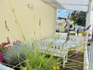 balcón con mesa, sillas y flores en Ferienhaus in Trittenheim mit Privatem Garten en Trittenheim