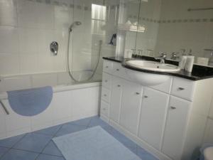 y baño blanco con lavabo y ducha. en Ferienhaus in Trittenheim mit Privatem Garten en Trittenheim