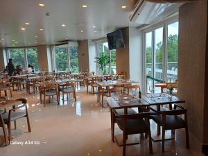 un restaurant avec des tables et des chaises en bois ainsi que des fenêtres dans l'établissement Laghetto Golden Resort, à Gramado