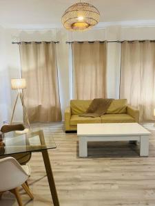een woonkamer met een bank en een tafel bij Le Petit Paradis : 2-4 pers WIFI in Boulogne-sur-Mer