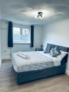 Deluxe Bungalow في Longham: غرفة نوم بسرير كبير بسقف