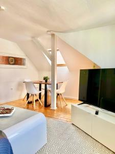 ein Wohnzimmer mit einem großen TV und einem Tisch in der Unterkunft Schönes City-Apartment mit 2 Schlafzimmer, Parkplatz, ruhig und hell, D46-DG in Oldenburg