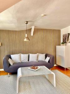 ein Wohnzimmer mit einem blauen Sofa und einem Tisch in der Unterkunft Schönes City-Apartment mit 2 Schlafzimmer, Parkplatz, ruhig und hell, D46-DG in Oldenburg