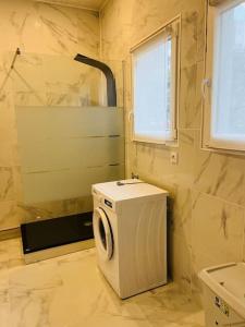 een kleine badkamer met een wasmachine en een raam bij Le Petit Paradis : 2-4 pers WIFI in Boulogne-sur-Mer