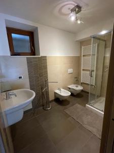 a bathroom with two sinks and a shower and a toilet at Villetta sulle dolomiti in Pracorno di Rabbi