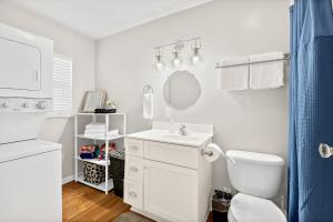 a white bathroom with a toilet and a sink at Cozy Uptown Guest House in Saint Augustine +17 photos