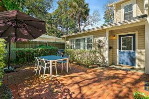 a patio with a table and chairs and an umbrella at Cozy Uptown Guest House in St. Augustine