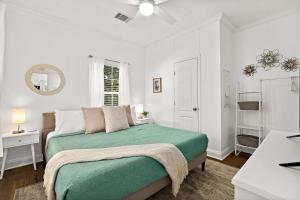 Habitación blanca con cama y baño. en Treetop Cottage - 3 blocks from Historic District en Saint Augustine