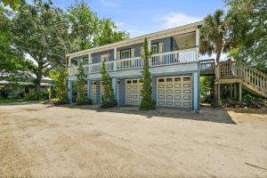 una grande casa con due porte garage e un balcone di Treetop Cottage - 3 blocks from Historic District a St. Augustine