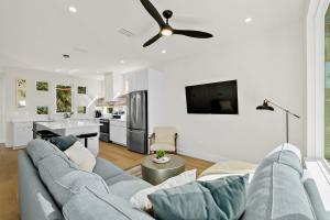 a living room with a blue couch and a ceiling fan at 196 Riberia - Downtown Waterfront Luxury Home in Saint Augustine