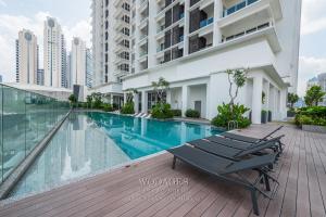 een zwembad met ligstoelen naast een gebouw bij Quill Residence by Wodages in Kuala Lumpur