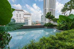 een zwembad in het midden van een stad met hoge gebouwen bij Quill Residence by Wodages in Kuala Lumpur