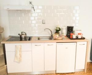 a kitchen with white cabinets and a sink at Perfect Stay in Cluj-Napoca