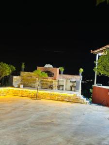 una casa por la noche con un banco delante en فيلا الجبل en Sūf