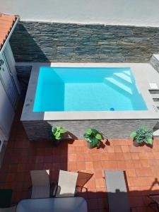 - une piscine sur une terrasse avec des chaises et des plantes dans l'établissement Vivenda Portela, à Covelinhas