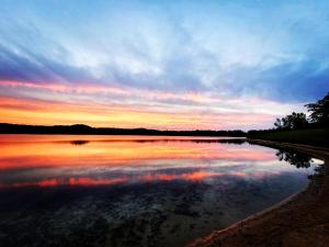 een zonsondergang boven een grote hoeveelheid water bij Tiny Digs Lakeshore - Tiny House Lodging in Muskegon