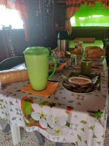 una mesa con una taza verde encima en Poemanahere island en Te-Fare-Arii