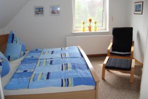 a bedroom with a bed and a chair and a window at Komfortable Ferienwohnung mit großem Garten in Lütjendorf