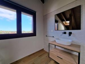 La salle de bains est pourvue d'un lavabo et d'un miroir. dans l'établissement Apartamento en Poo de Llanes, à Poo de Llanes
