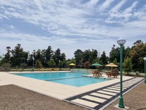 a swimming pool with tables and umbrellas at Grand Mer Hotel Seogwipo Ocean in Seogwipo