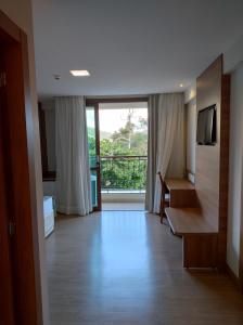 ペドラ・アズールにあるVista Azul Apart Hotel - Vista Pedra Azulの大きな窓のある廊下があるホテルの部屋
