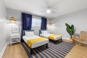 a bedroom with two beds and a table and a chair at Island Suite - Walk to Downtown! in St. Augustine