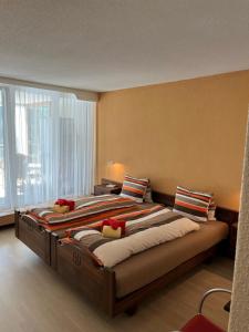 een groot bed in een kamer met een groot raam bij Tulai D74 in Scuol