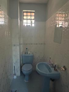 bagno con servizi igienici blu e lavandino di Jojo's Homestay - Bomet Town a Bomet