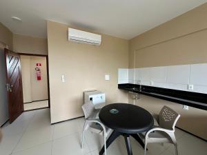 een keuken met een tafel en stoelen in een kamer bij Apartamento no Centro do Cumbuco in Cumbuco