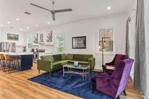 uma sala de estar com um sofá e uma mesa em Luxury New 3BD Home with Parking and Private Yard em Nova Orleans