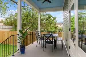 - une terrasse couverte avec une table et des chaises dans l'établissement Luxury New 3BD Home with Parking and Private Yard, à La Nouvelle-Orléans