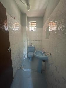 bagno con lavandino blu e servizi igienici di Jojo's Homestay - Bomet Town a Bomet